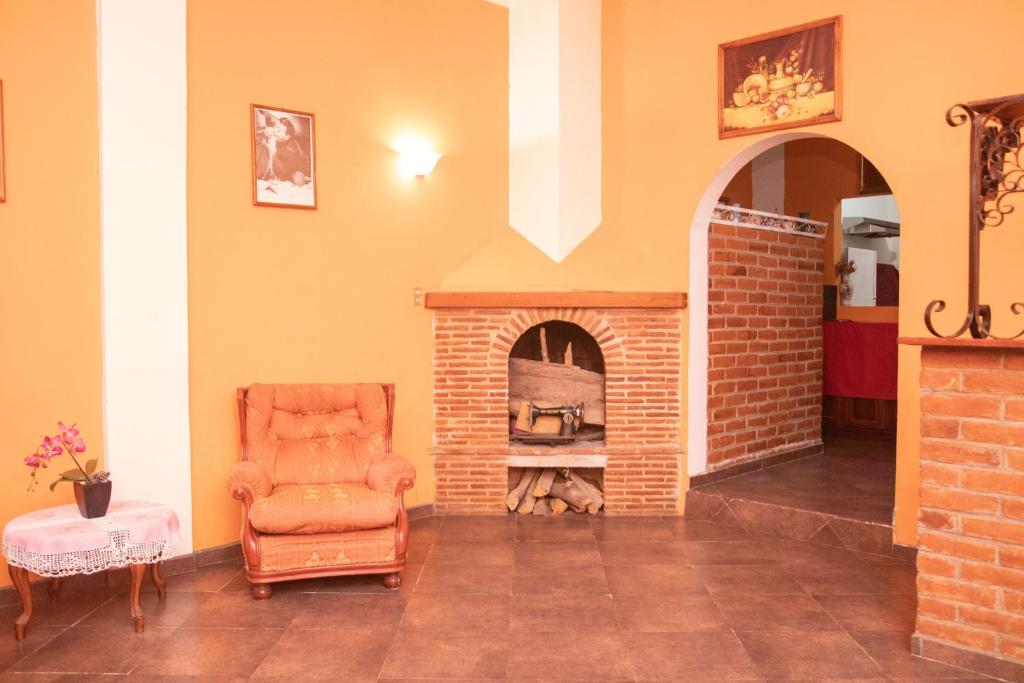 a living room with a chair and a brick fireplace at La Casa de Nina in Juayúa