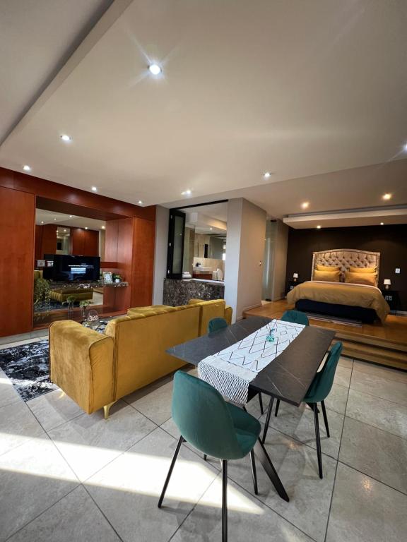 a living room with a bed and a table and chairs at Luxury unit in Johannesburg