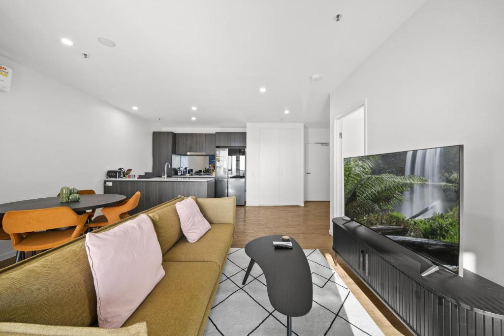 a living room with a couch and a flat screen tv at Refined 2-Bed With Luxurious Building Amenities in Belconnen