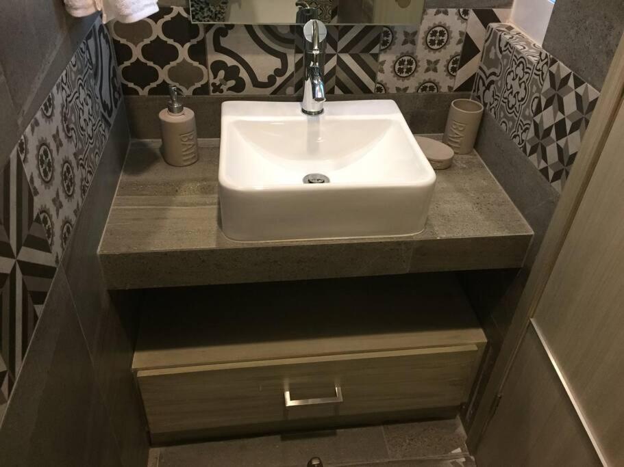 ein weißes Waschbecken im Bad mit Theke in der Unterkunft Departamento amueblado de lujo in La Concepción