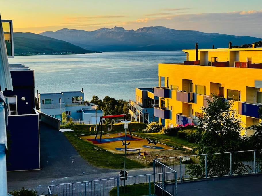 Un edificio con una cancha de baloncesto frente al agua. en Studio apartamento em Tromsø Noruega, en Tromsø