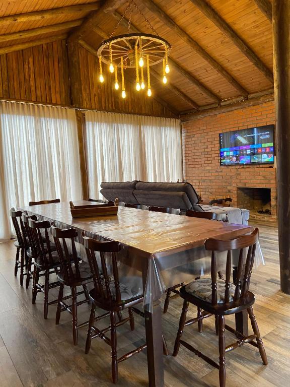 a dining room with a large wooden table and chairs at Refúgio Rota das Nuvens in Bom Jardim da Serra