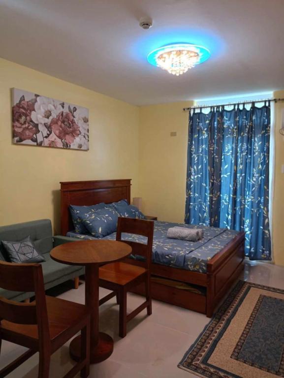 a bedroom with a bed and a table and chairs at Zhabret's Place II in Lapu Lapu City