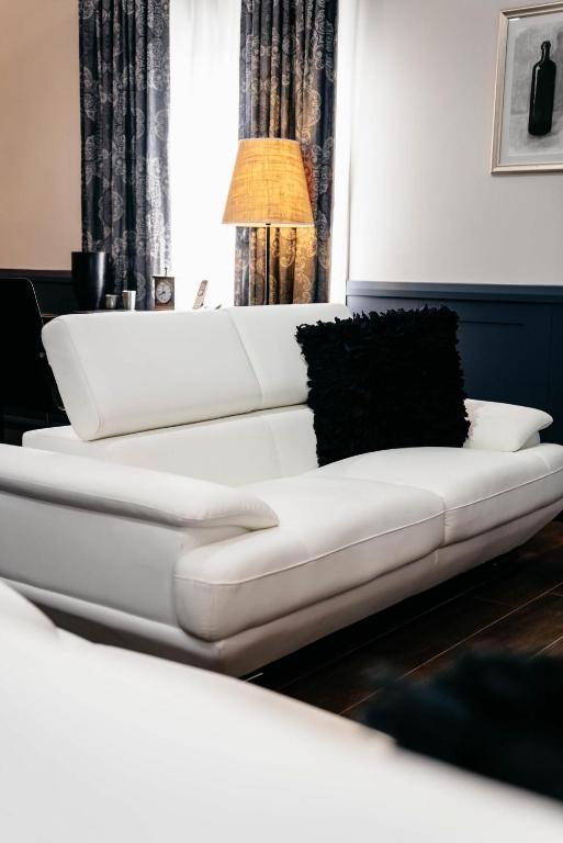 a white couch in a living room with a lamp at de Russie Boutique Hotel in Orange