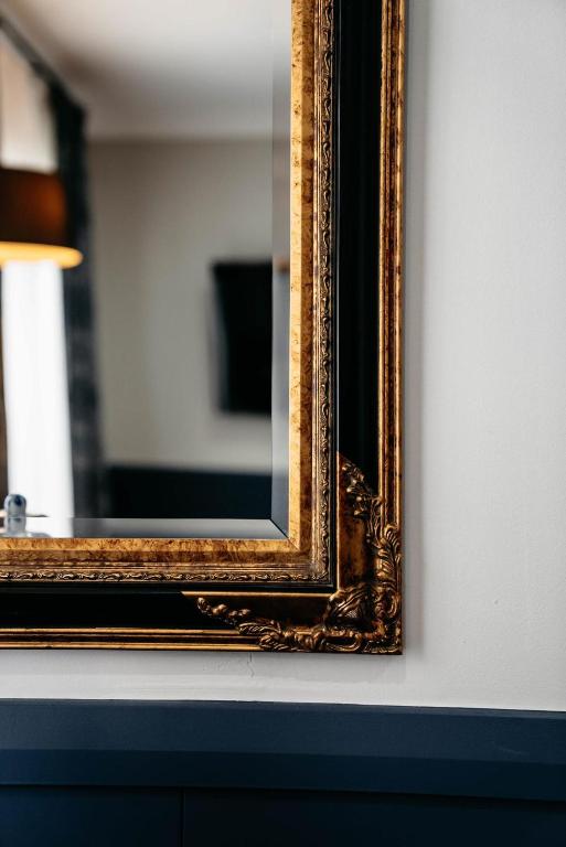 a mirror on a wall next to a table at de Russie Boutique Hotel in Orange