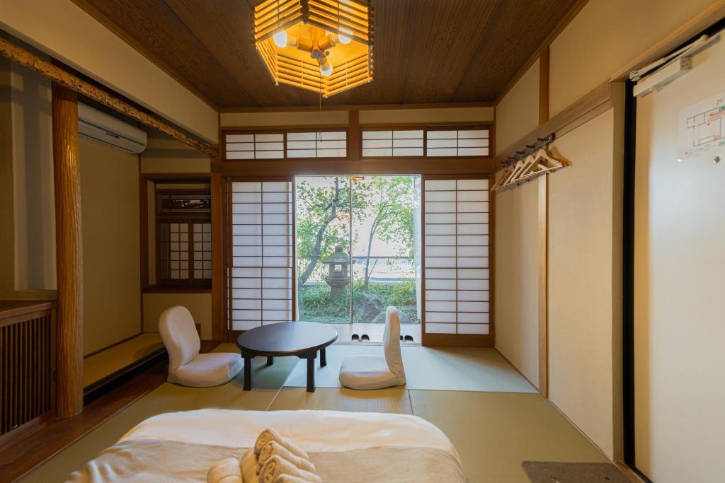 a room with a bed and a table and chairs at RELAX Condo Namba Daikokucho in Osaka