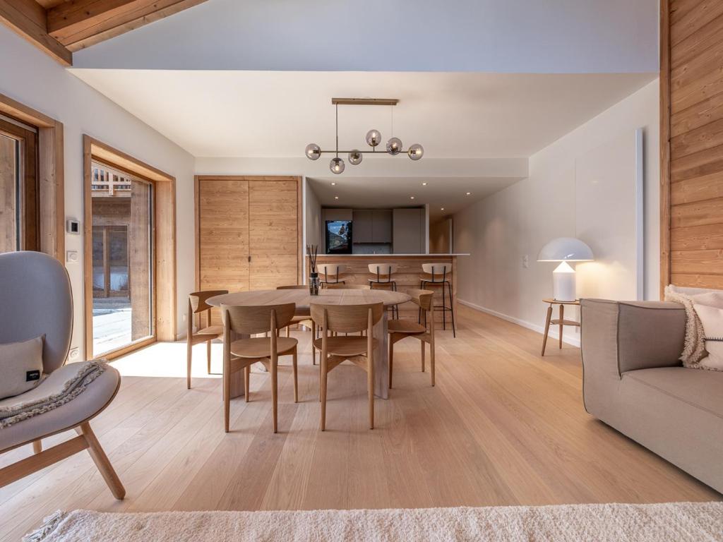 une salle à manger et un salon avec une table et des chaises dans l'établissement Bel appartement moderne à Méribel Mottaret avec terrasse - 6 pers - FR-1-613-118, à Les Allues