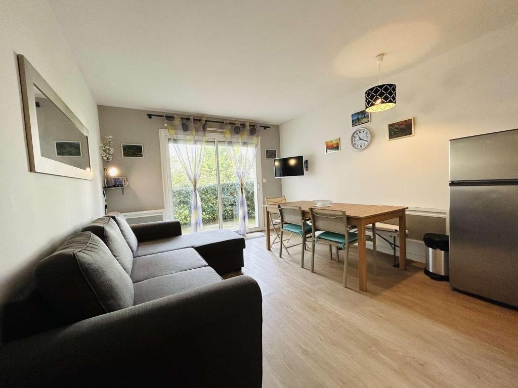 un salon avec un canapé et une table dans l'établissement Appartement 2 pièces cabine avec jardin, proche centre et marché - 4 couchages, Le Pouliguen - FR-1-245-208, au Pouliguen