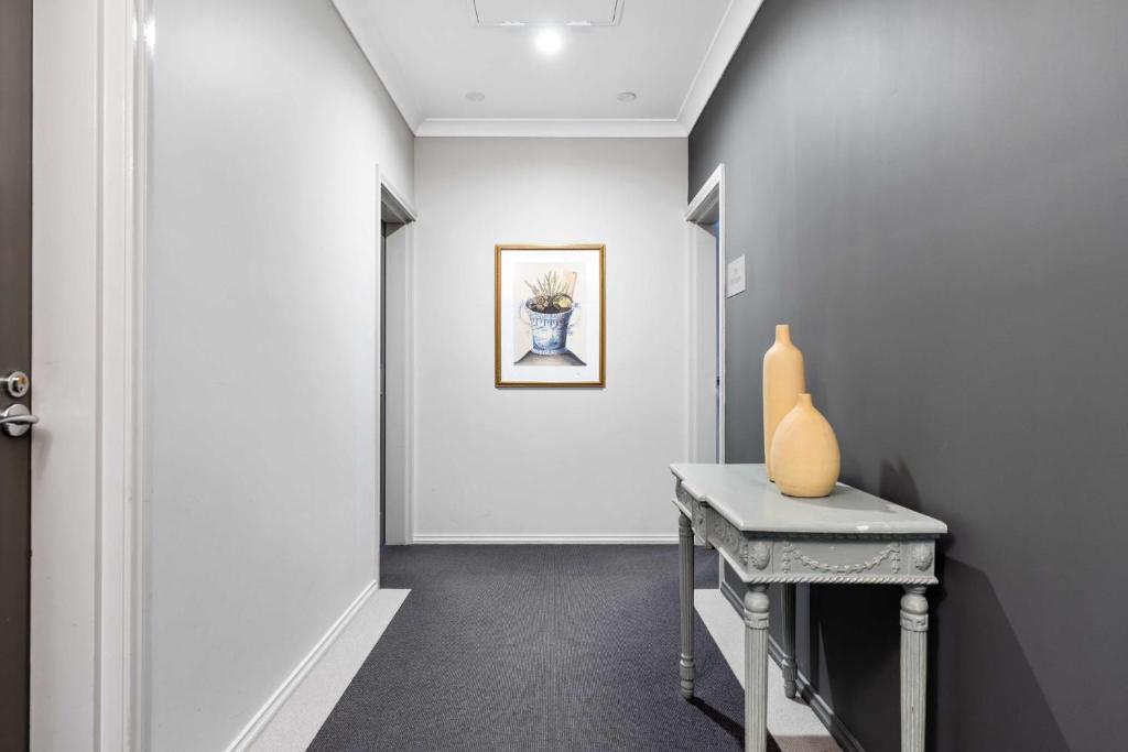 a hallway with a table and a vase on it at de Russie Boutique Hotel in Orange