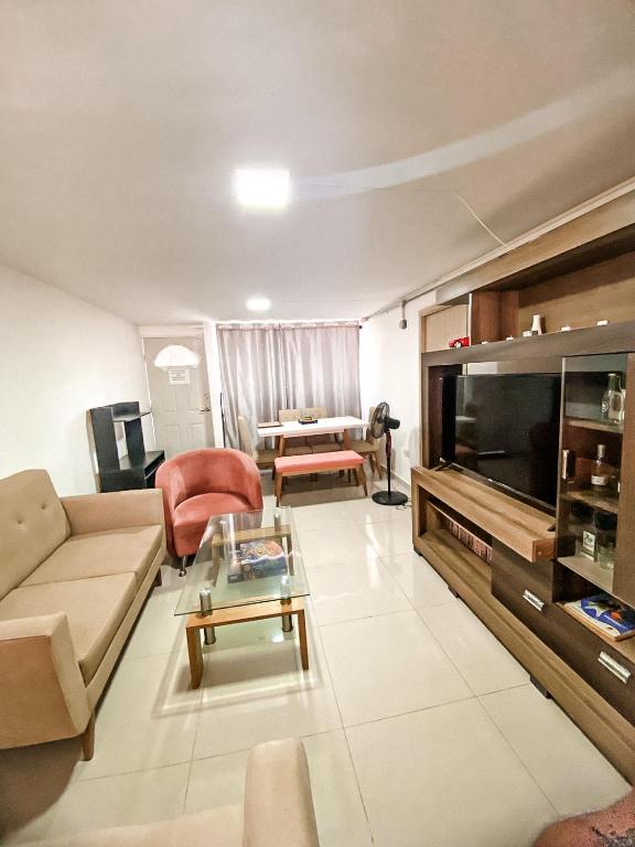 a living room with a couch and a tv at Apto cerca Estadio Metropolitano in Barranquilla