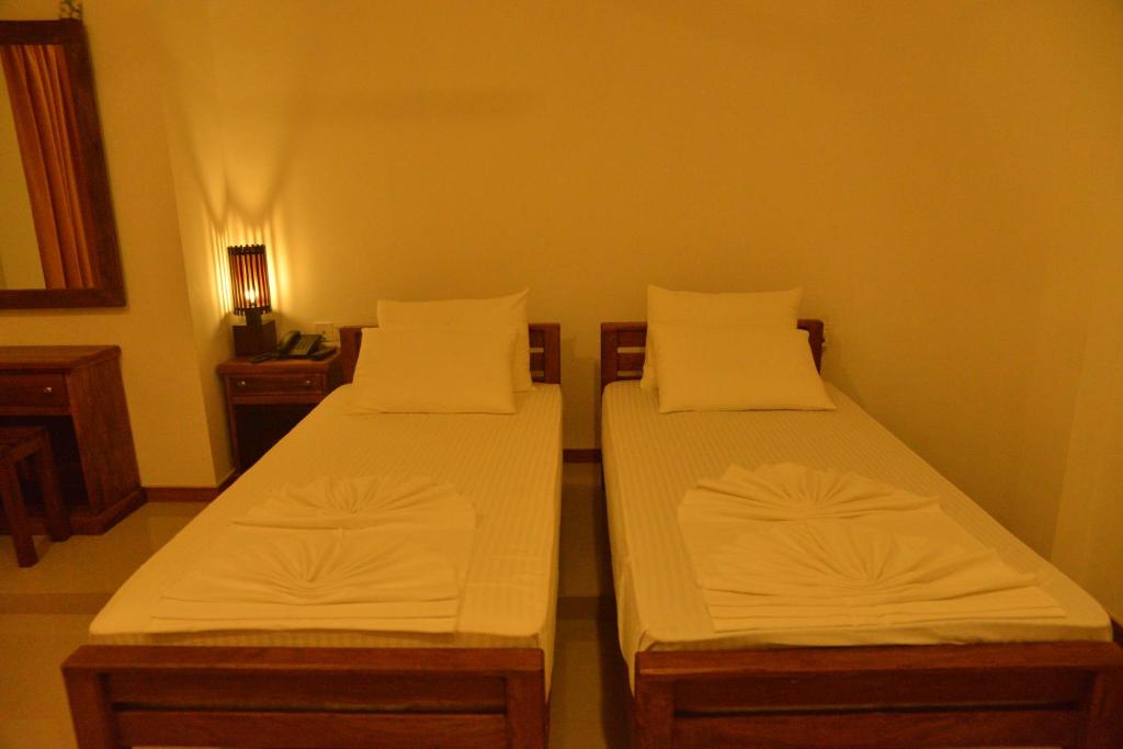 Postel nebo postele na pokoji v ubytování Rajarata Family Resort