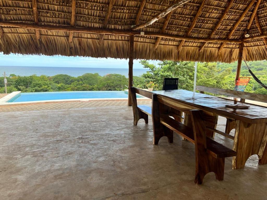 a desk in a straw hut with a laptop on it at Rancho Agua Fria casa in Usulután