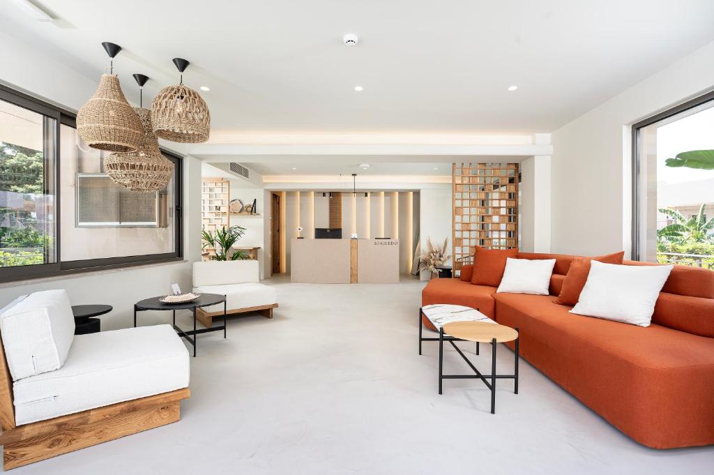 a living room with an orange couch and chairs at Sagredo Boutique Hotel & Spa in Ágios Fokás