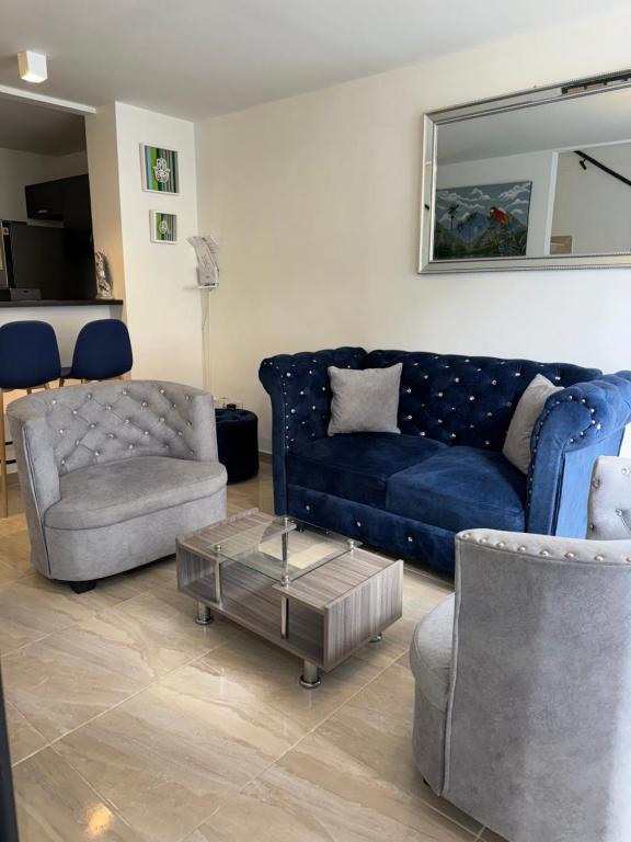 a living room with a blue couch and a chair at Casa Villa Paz Salento in Salento