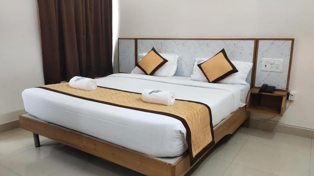 蒂鲁帕蒂Hotel Vintage inn的一间卧室，配有一张大床和两个枕头