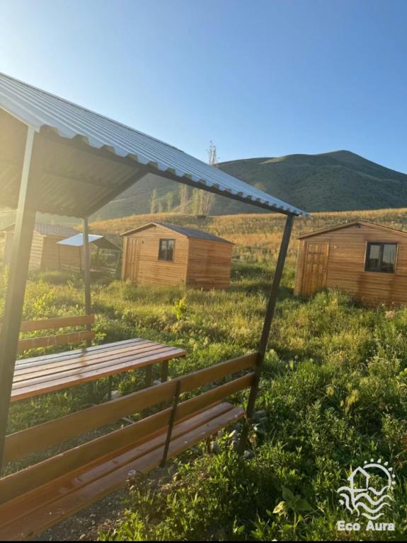 a bench in a field with houses in the background at Eco Aura (rest zone / Sevan / Отдых) in Areguni