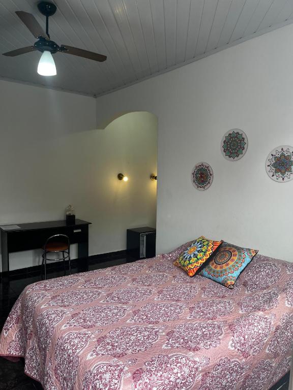 a bedroom with a bed with two pillows on it at Pousada Jandi in São Miguel Arcanjo