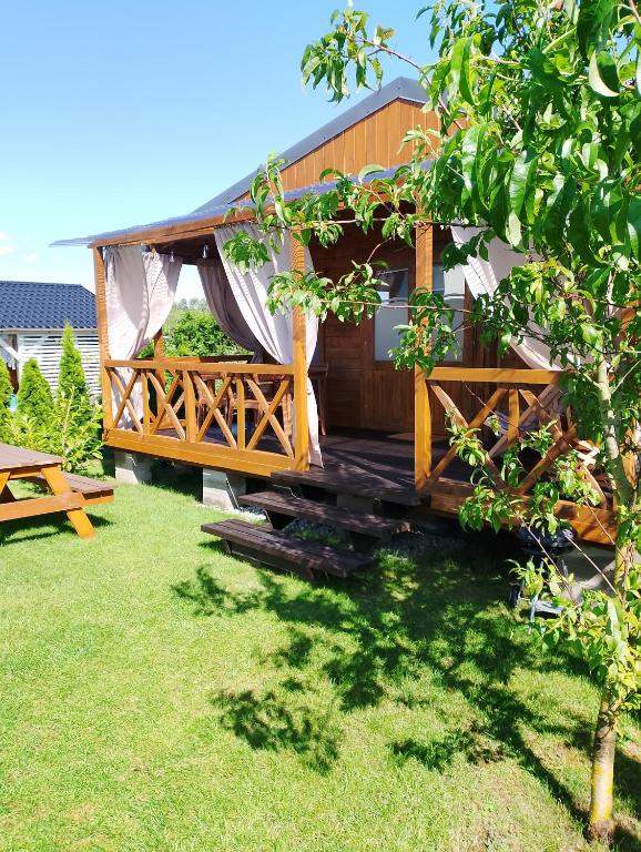 a tree house with a deck in a yard at słoneczny domek II in Kołczewo