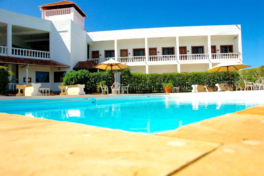 a large swimming pool in front of a building at Galu Inn in Diani Beach