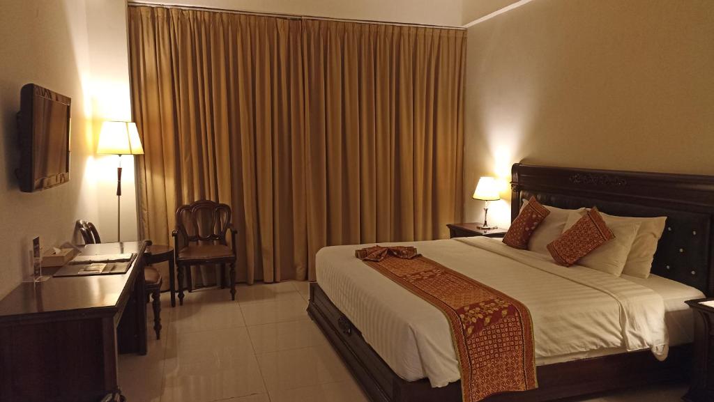 Postel nebo postele na pokoji v ubytování The Rich Jogja Hotel