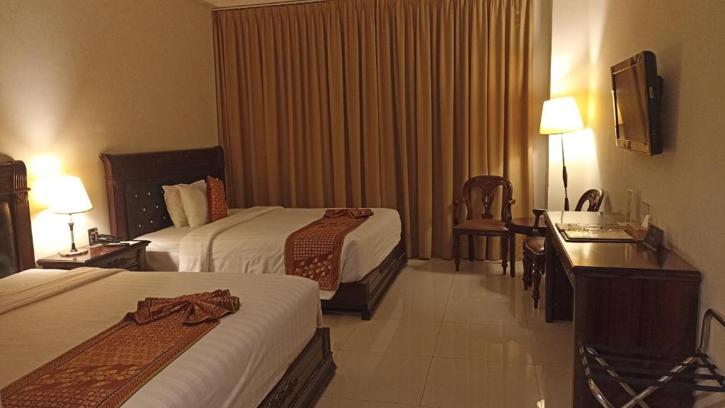 Postel nebo postele na pokoji v ubytování The Rich Jogja Hotel