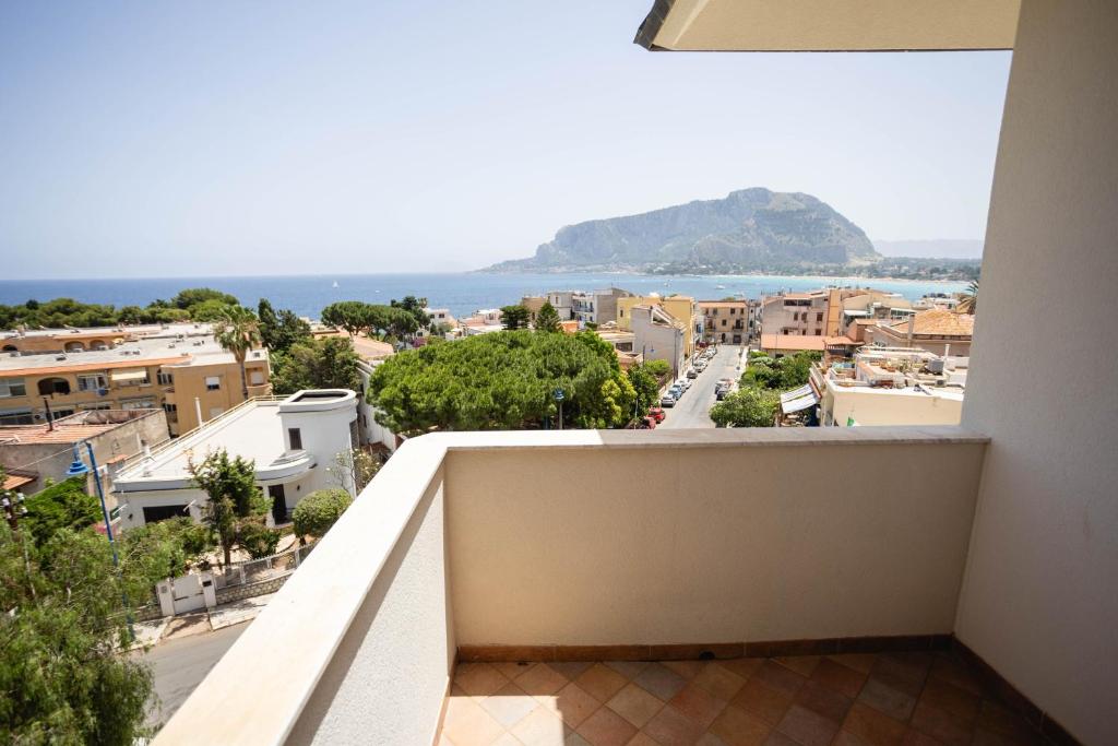 a balcony with a view of a city and the ocean at Mondello Glam Hotel & Terrace in Mondello