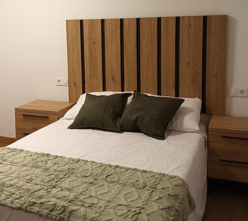 une chambre avec un grand lit avec deux tables de nuit dans l'établissement Apartamentos Rural La Perla, à Becilla de Valderaduey