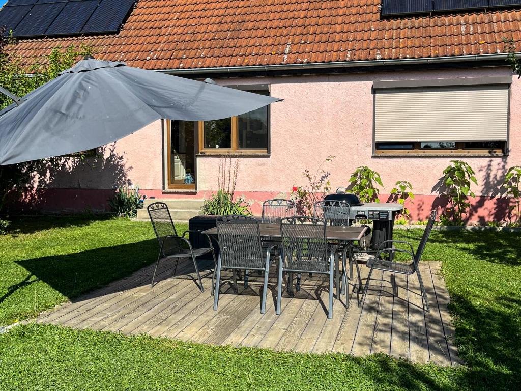 a patio with a table and chairs and an umbrella at Ferienwohnung auf dem Alpaka-Hof in Rubkow