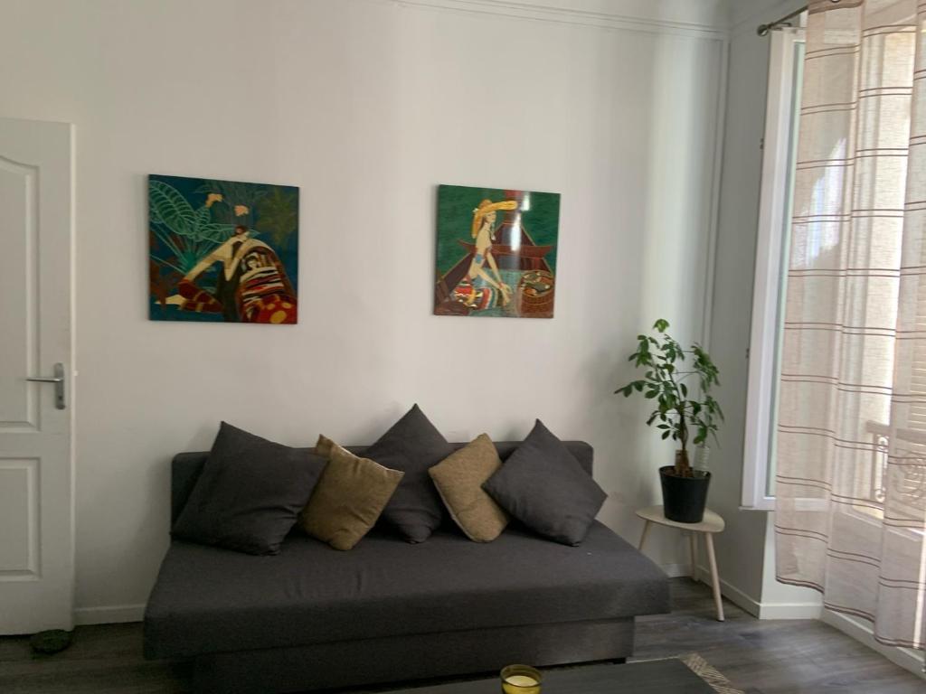 - un canapé dans le salon orné de 3 peintures murales dans l'établissement Quartier Trendy proche de Tous les sites, à Marseille