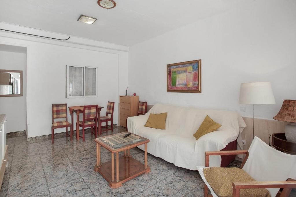 ein Wohnzimmer mit einer weißen Couch und einem Tisch in der Unterkunft Casa de Jordan in Castillo del Romeral