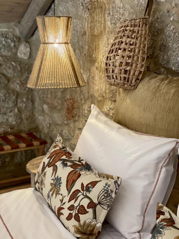 a lamp sitting next to a bed with a pillow at Selene Luxury Rooms in Sinevrón