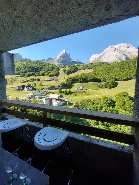 d'un balcon avec deux tables et une vue sur les montagnes. dans l'établissement Studio cosy à la station, à Eaux-Bonnes