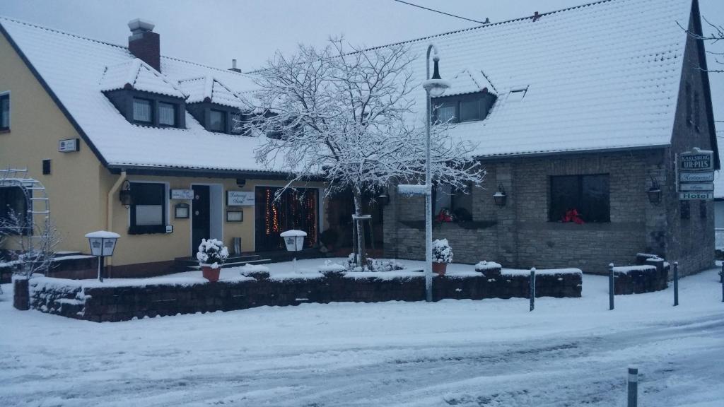 una casa con la neve per terra davanti di Hotel Am Markt a Kleinblittersdorf