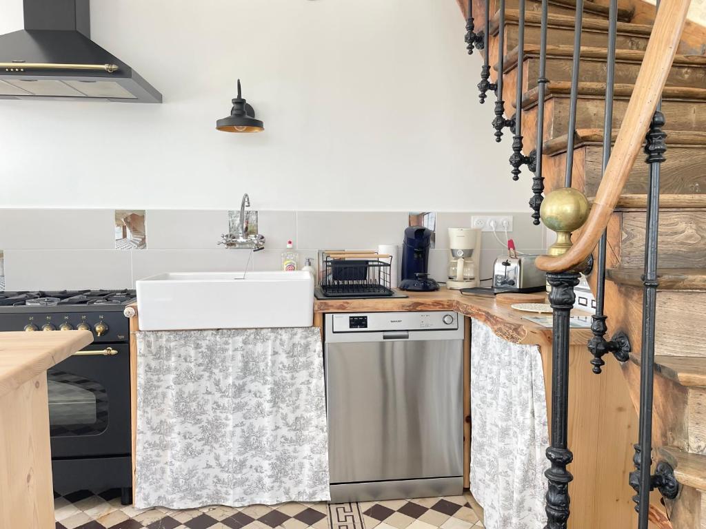 Kuchyň nebo kuchyňský kout v ubytování La clairiere Maison spacieuse rénovée joliment décorée tout confort 12 p 2 sdb 2 wc grand jardin clos, belle terrasse aménagée, parking privatif, ping pong baby foot proche Omaha Beach et Bayeux