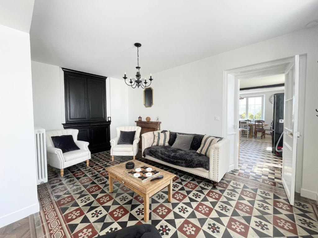 Posezení v ubytování La clairiere Maison spacieuse rénovée joliment décorée tout confort 12 p 2 sdb 2 wc grand jardin clos, belle terrasse aménagée, parking privatif, ping pong baby foot proche Omaha Beach et Bayeux