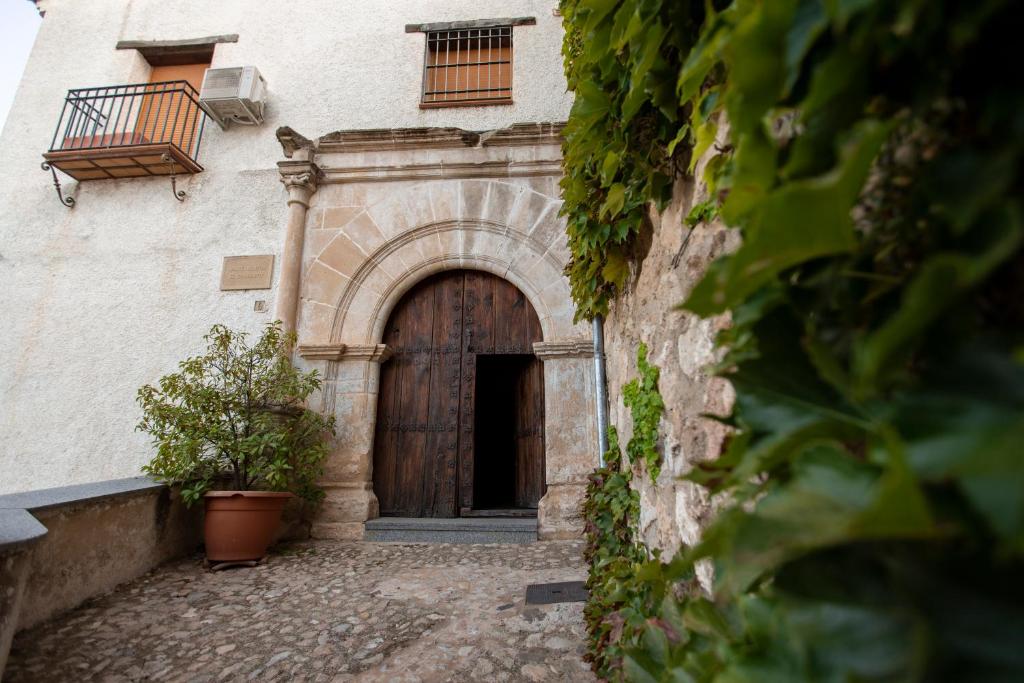 a building with a wooden door with a balcony at apartamento Dolina in Segura de la Sierra