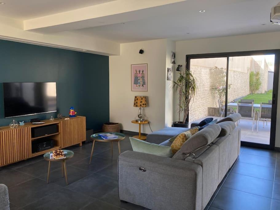 un salon avec un canapé et une télévision à écran plat dans l'établissement Très belle maison moderne ,hyper centre de Bayeux, à Bayeux