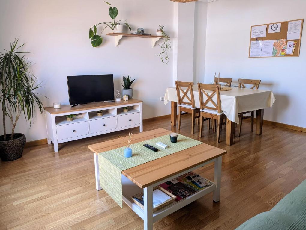 a living room with a table and a tv at Puerta del Noroeste in Benavente