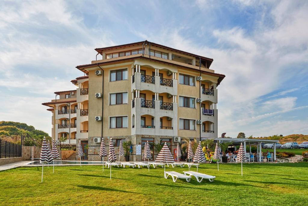 ein großes Gebäude mit Bänken davor in der Unterkunft Toma's Residence - Front Beach in Zarewo