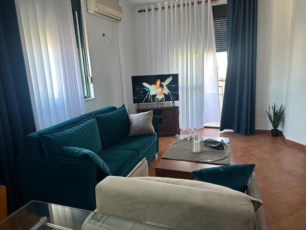 a living room with a blue couch and a table at Elois Center Apartament in Tirana