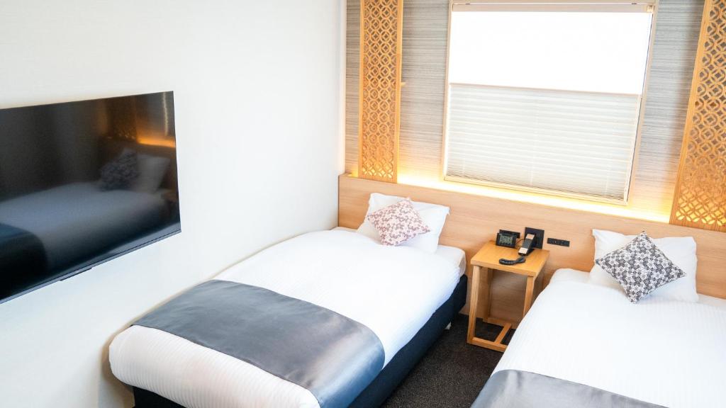 Postel nebo postele na pokoji v ubytování Tabist kiki HOTEL KYOTO Gojo Karasuma