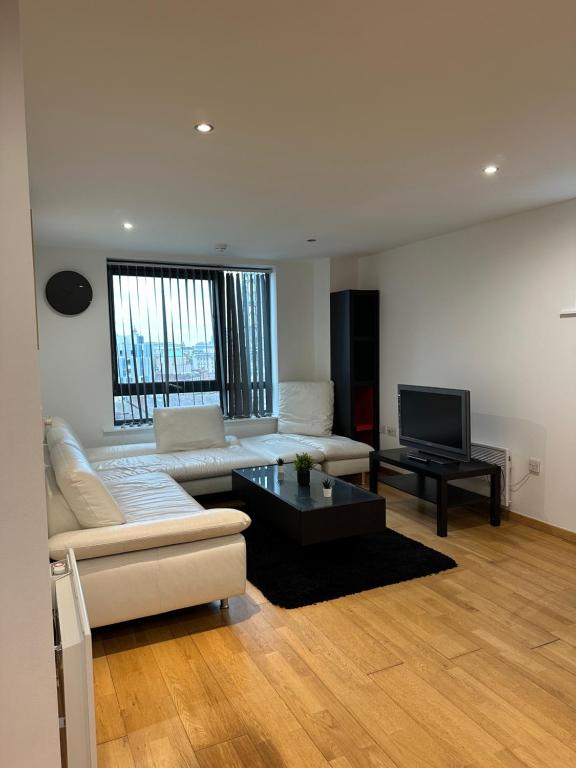 ein Wohnzimmer mit Sofa und Fernseher in der Unterkunft City Centre 2 Bed Room 2 Bath Room Apartment with En-suite in Liverpool