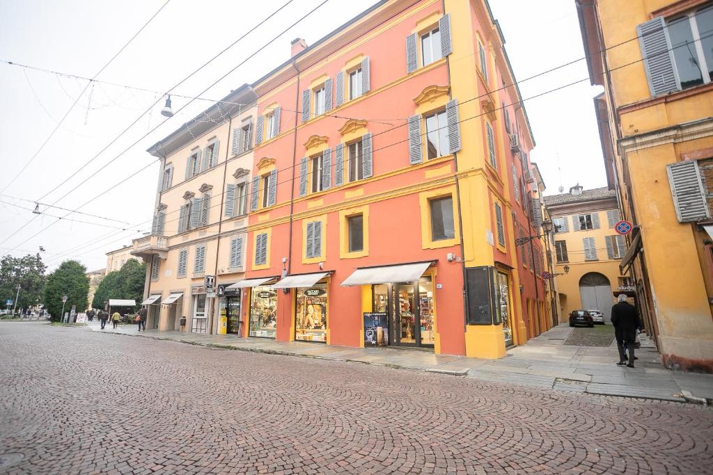 a orange and yellow building on the side of a street at Center Vicolo Suite Apartment with Parking in Modena