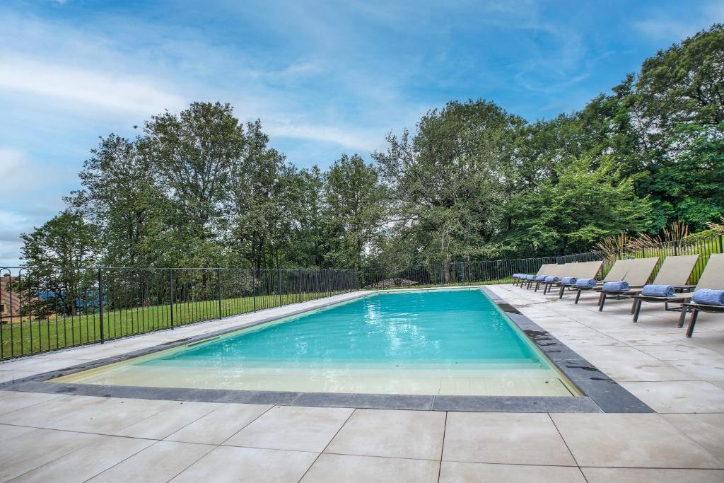 une piscine avec des chaises et une clôture dans l'établissement Les Hauts de Chaunac - Dar Diaf, à Vitrac