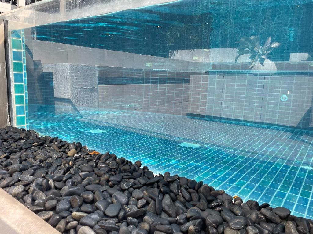 een zwembad met rotsen eromheen bij Delight Home in Amphoe Phra Khanong