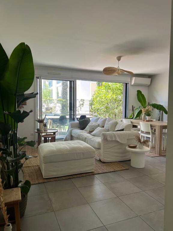 un salon avec un canapé blanc et une table dans l'établissement Maison avec Jardin, à Baillargues