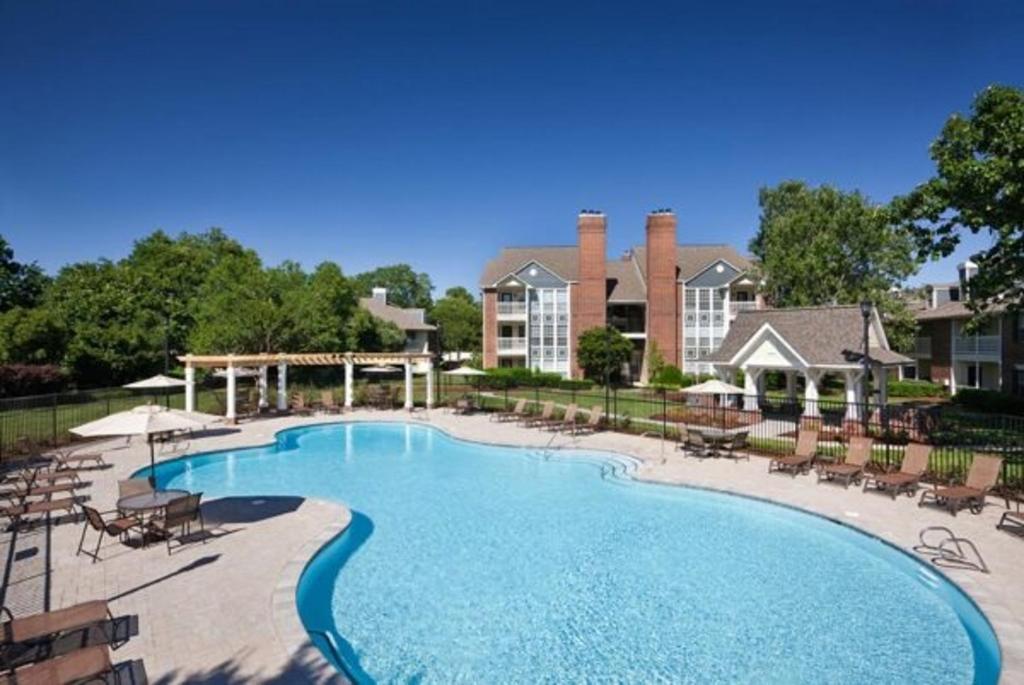 a large swimming pool with chairs and a resort at Wyndham 219 Modern 2br Suite, Parking in Hampton