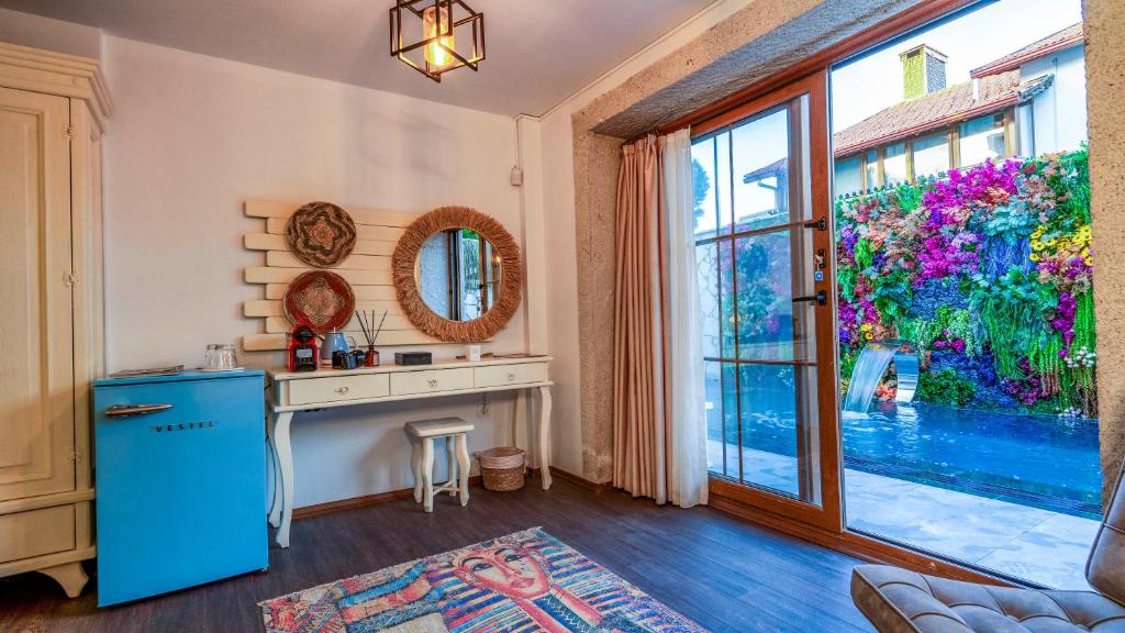 a kitchen with a blue refrigerator and a large window at Lulu Inn Cesme in Çeşme