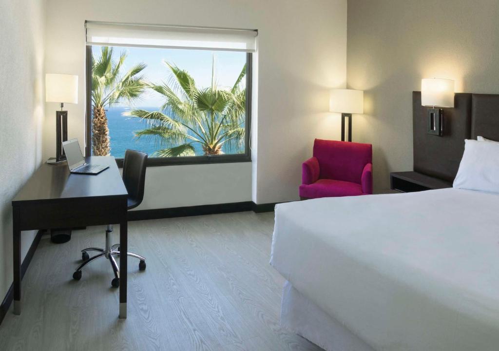 Una cama o camas en una habitación de NH Iquique Costa