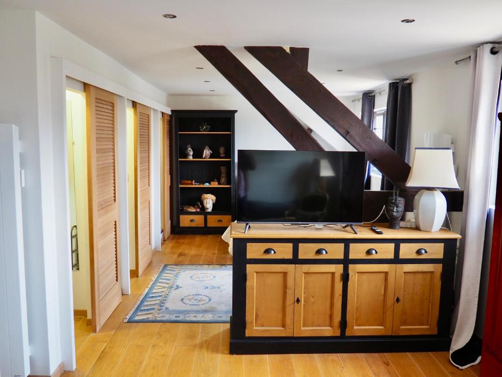 - un salon avec une télévision à écran plat sur une armoire en bois dans l'établissement Auberge du Cronquelet, à Saint-Aubin